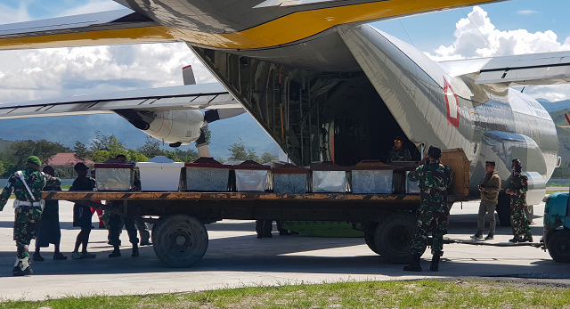 indonesian military officers load coffins into a carrier aircraft in wamena papua province on december 6 2018 photo afp