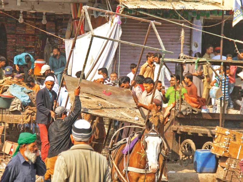 workers of hyderabad municipal corporation s anti encroachment cell remove vendors and push carts from latifabad number 12 photo inp