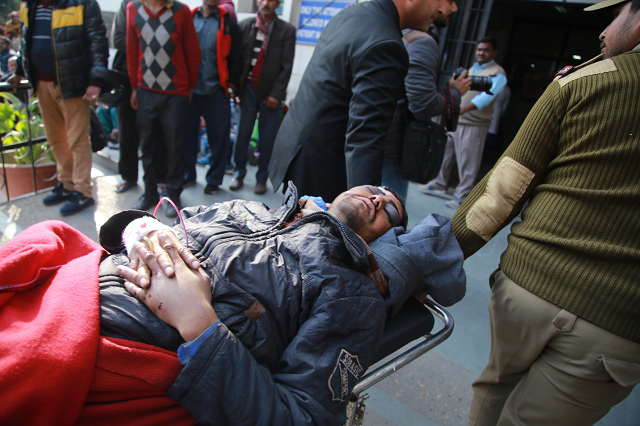 an injured passenger hurt when his bus fell into a gorge in the mountains of poonch photo afp
