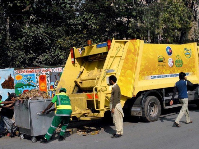 workers of lahore waste management company busy in removing the garbage photo app file