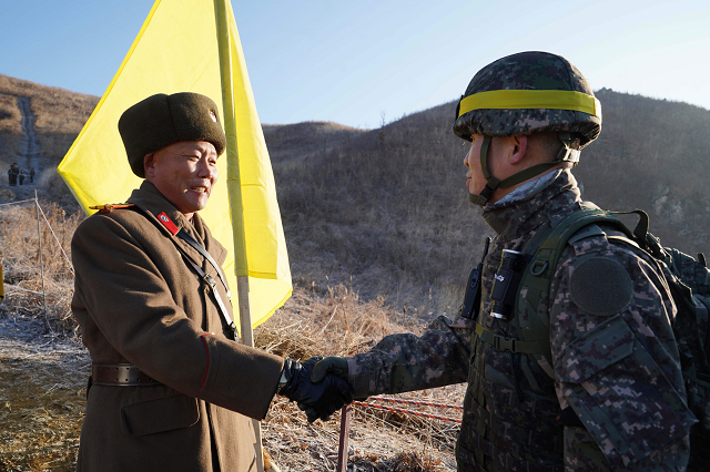 this handout photo taken on december 12 2018 and provided by south korean defence ministry shows a south korean soldier r shaking hands with a north korean soldier l before crossing the military demarcation line to inspect the dismantled north korean guard post inside the demilitarised zone dmz dividing the two koreas in cheorwon photo afp this handout photo taken on december 12 2018 and provided by south korean defence ministry shows a south korean soldier r shaking hands with a north korean soldier l before crossing the military demarcation line to inspect the dismantled north korean guard post inside the demilitarised zone dmz dividing the two koreas in cheorwon photo afp