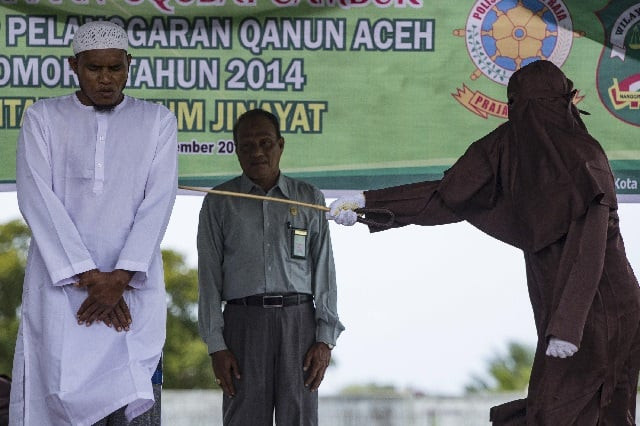 a sharia law enforcement official whips a man in lhokseumawe in aceh province photo afp a sharia law enforcement official whips a man in lhokseumawe in aceh province photo afp