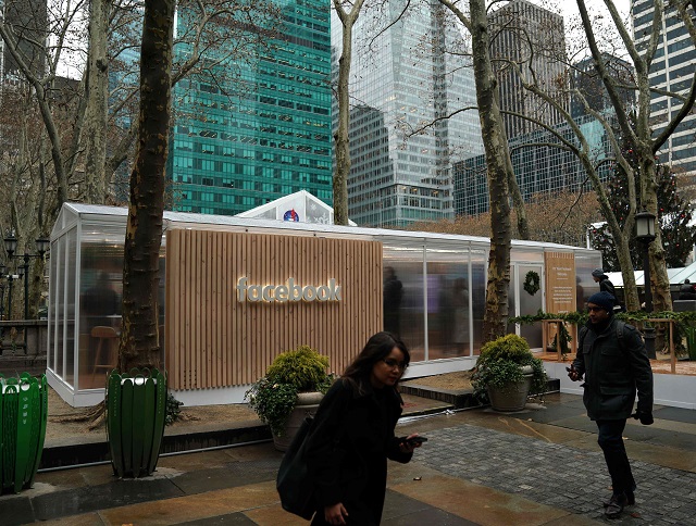 people walk by as the social network facebook opens a pop up kiosk for one day on december 13 2018 in bryant park in new york photo afp