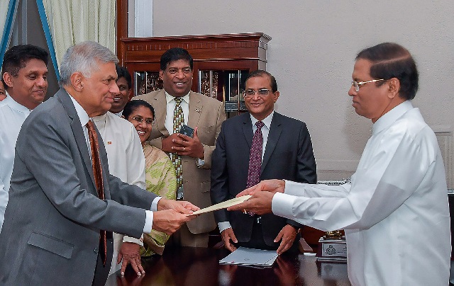 sri lankan president maithripala sirisena r handing over documents to ranil wickremesinghe l as he is reappointed as prime minister in colombo photo afp