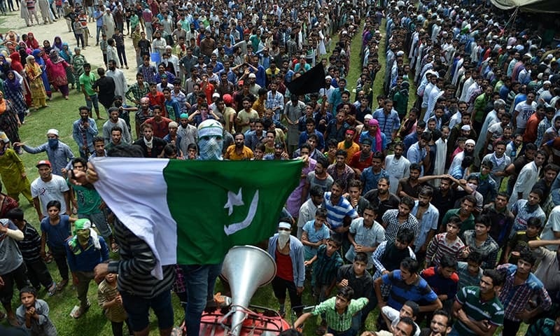 a masked kashmiri mourner holds up a pakistani flag as others shout anti  indian slogan photo afp