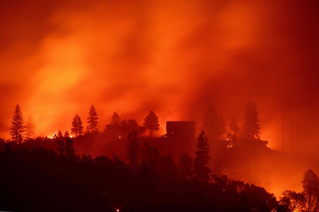 in this file photo taken on november 11 2018 flames from the camp fire burn near a home atop a ridge near big bend california   luanne wright was all set for retirement when the deadliest wildfire in california history swept through her town of paradise the blaze incinerated her home her car and even the chickens in her backyard insurance claims have already topped 7 billion and officials estimate it will cost at least 3 billion just to clear the charred debris of homes and businesses her house was worth 200 000 the government gave her 34 900 to rebuild   enough she says to just about cover the cost of a new kitchen photo afp