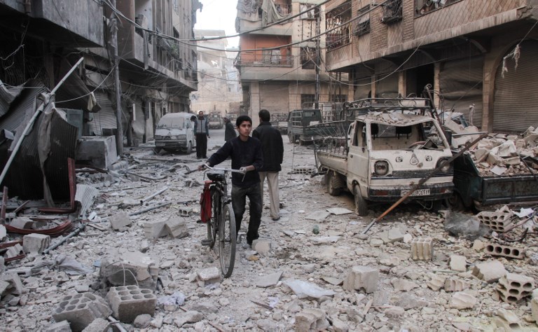 a syrian boy pushes a bicycle down a street amidst the destruction photo reuters