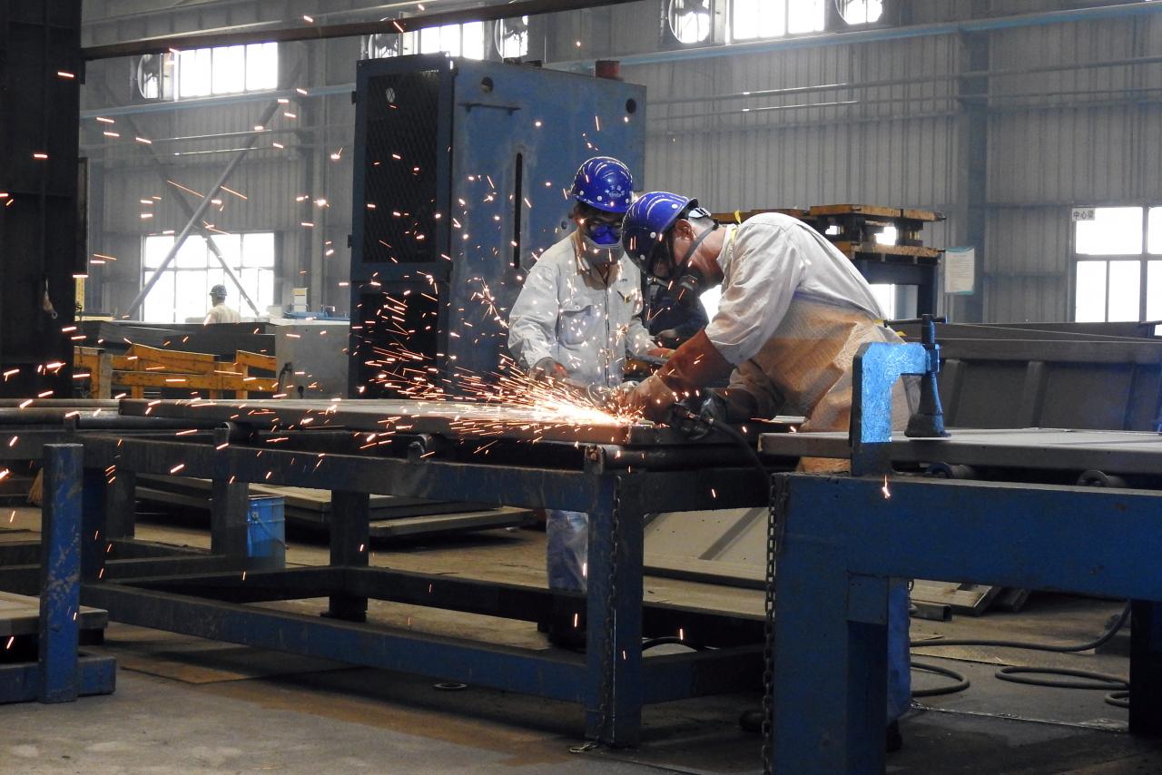 workers weld shipping container components at a container manufacturing company photo reuters