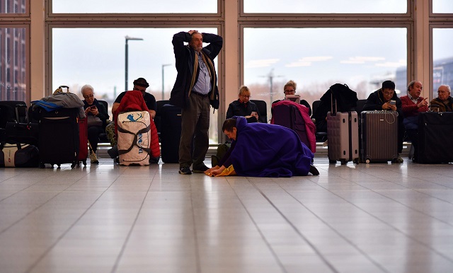 passengers sit with their luggage in the south terminal building at london gatwick airport south of london on december 21 2018 as flights started to resume following the closing of the airfield due to a drones flying photo afp