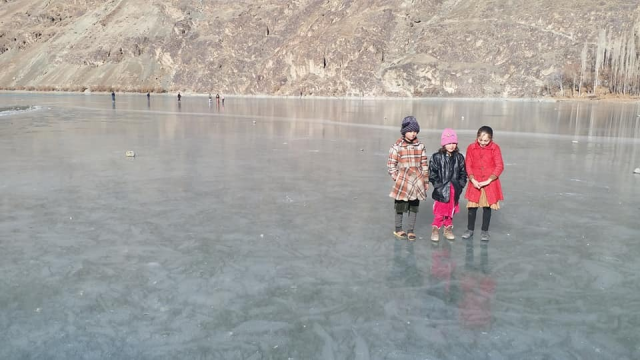 children stand on a frozen lake near gilgit baltistan children stand on a frozen lake near gilgit baltistan