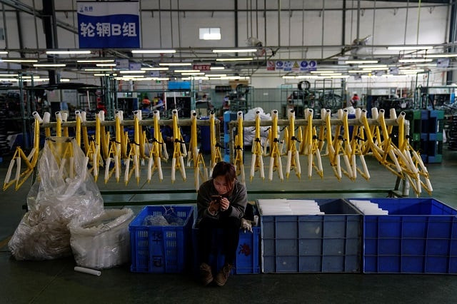 a woman uses her mobile phone as she sits next to bicycle frames for chinese bike sharing service ofo at a bicycle factory in jinghai district of tianjin china march 11 2017 photo reuters a woman uses her mobile phone as she sits next to bicycle frames for chinese bike sharing service ofo at a bicycle factory in jinghai district of tianjin china march 11 2017 photo reuters