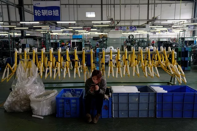 a woman uses her mobile phone as she sits next to bicycle frames for chinese bike sharing service ofo at a bicycle factory in jinghai district of tianjin china march 11 2017 photo reuters a woman uses her mobile phone as she sits next to bicycle frames for chinese bike sharing service ofo at a bicycle factory in jinghai district of tianjin china march 11 2017 photo reuters