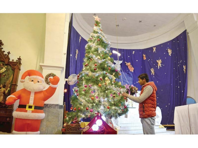 a man decorates a christmas tree in cathedral church lalkurti while shops still doing brisk business of selling novelties in rawalpindi photos agencies a man decorates a christmas tree in cathedral church lalkurti while shops still doing brisk business of selling novelties in rawalpindi photos agencies