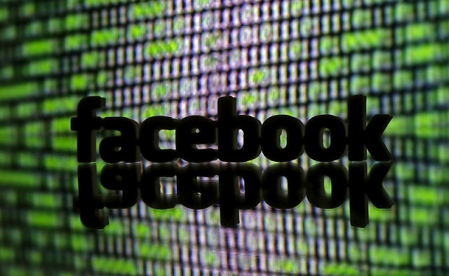 a 3d printed facebook logo is seen in front of displayed cyber code in this illustration taken march 22 2016 photo reuters