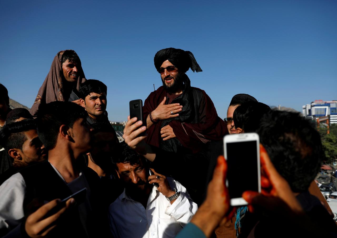 people take selfies with a taliban in kabul afghanistan photo reuters