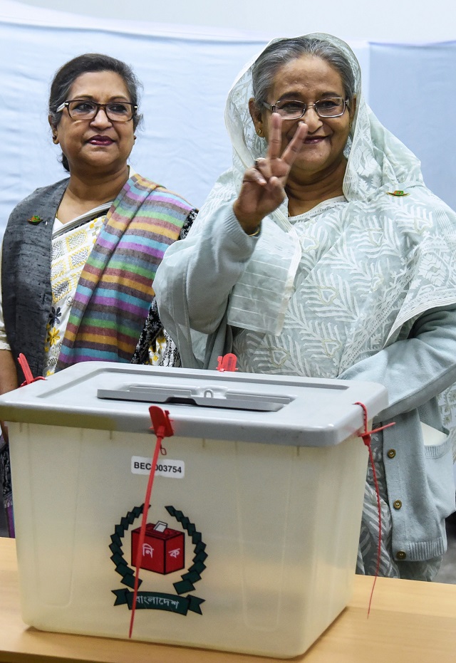 bangladeshi prime minister sheikh hasina r flashes the victory symbol after casting her vote as her sister sheikh rehana l looks on at a polling station in dhaka on december 30 2018   bangladesh headed to the polls on december 30 following a weeks long campaign that was dominated by deadly violence and allegations of a crackdown on thousands of opposition activists photo afp