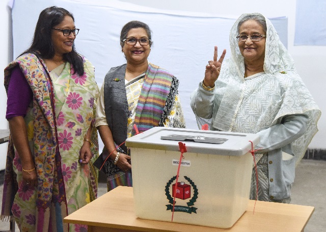 bangladeshi prime minister sheikh hasina r flashes the victory symbol after casting her vote as her daughter saima wazed hossain 1st l and her sister sheikh rehana 2nd l look on at a polling station in dhaka photo afp