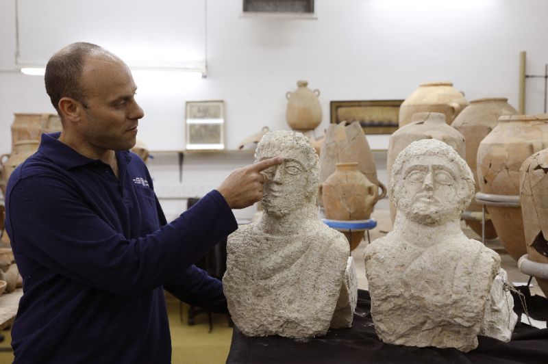 israeli archaeologist eitan klein of the israel antiquities authority shows off two late roman busts unearthed near the ancient city of beit shean following a chance find by a woman walker photo afp