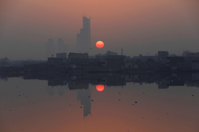 the first sun of the new year is reflected in water at the china creek area in karachi photo afp