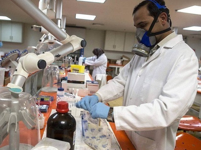 forensic scientists analyse samples at the punjab forensic science agency photo reuters