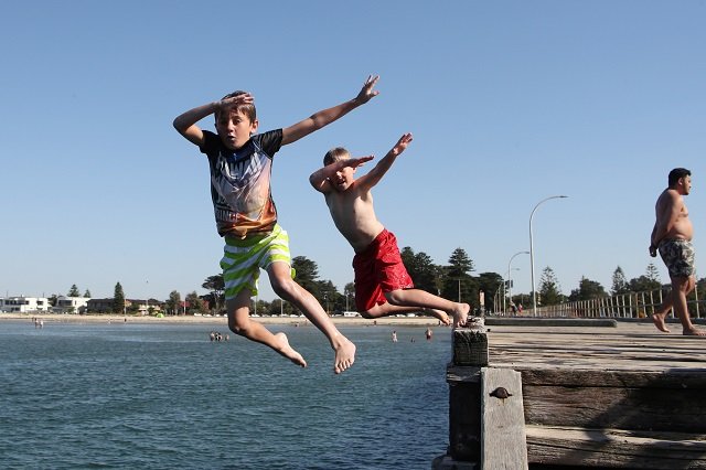 children jump into the water off altona pier in melbourne australia photo reuters