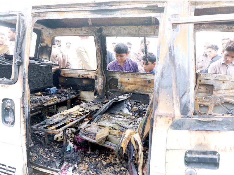 children look into the burnt out hi roof van which caught fire because of short circuit photo online