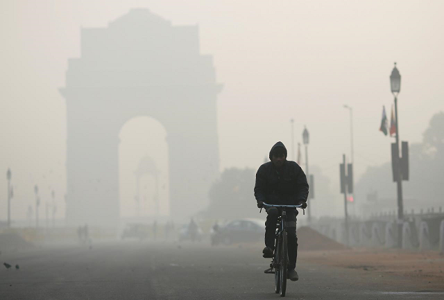 a man rides his bicycle in front of the india gate shrouded in smog in new delhi india december 26 2018 photo reuters