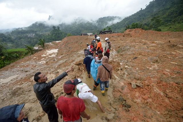 in this file photo taken on january 1 2019 rescue workers search for survivors at the site of a landslide triggered by heavy rain in sukabumi west java province photo afp