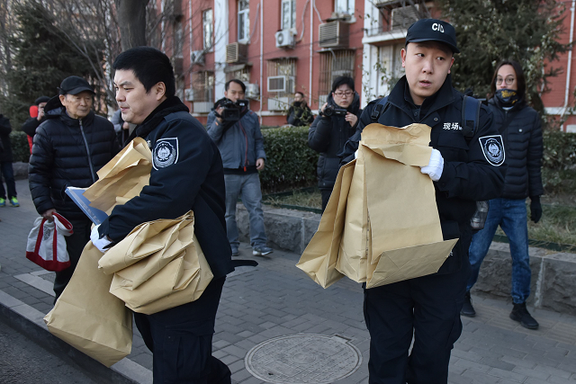 police investigators carry bags of evidence out of an elementary school where an attack took place in beijing photo afp