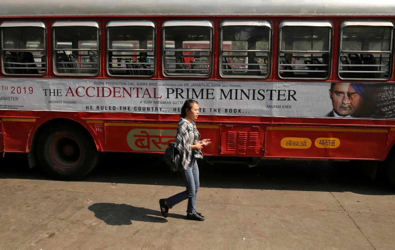 a woman walks past a bus featuring an advertising of the upcoming bollywood film quot the accidental prime minister quot in mumbai india photo reuters