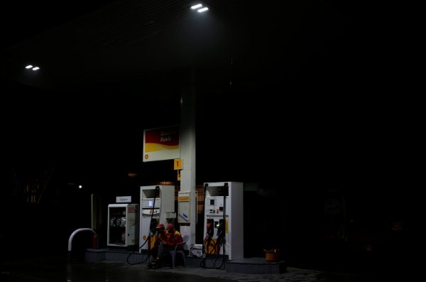 employees sit next to fuel pumps photo reuters