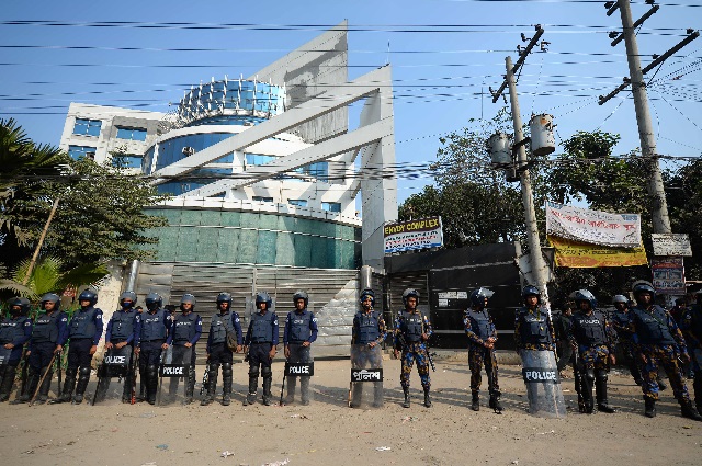 bangladeshi police stand guard in front of a garment factory in ashulia on the outskirts of dhaka on january 14 2019 photo afp