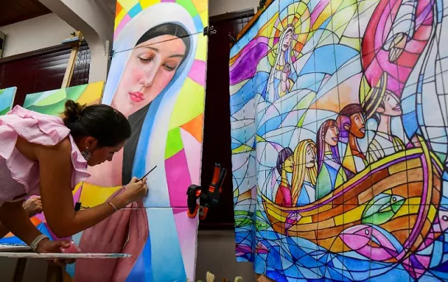 a woman works on a panel that will be part of a giant mural forming the backdrop to a papal mass during world youth day celebrations in panama photo afp a woman works on a panel that will be part of a giant mural forming the backdrop to a papal mass during world youth day celebrations in panama photo afp