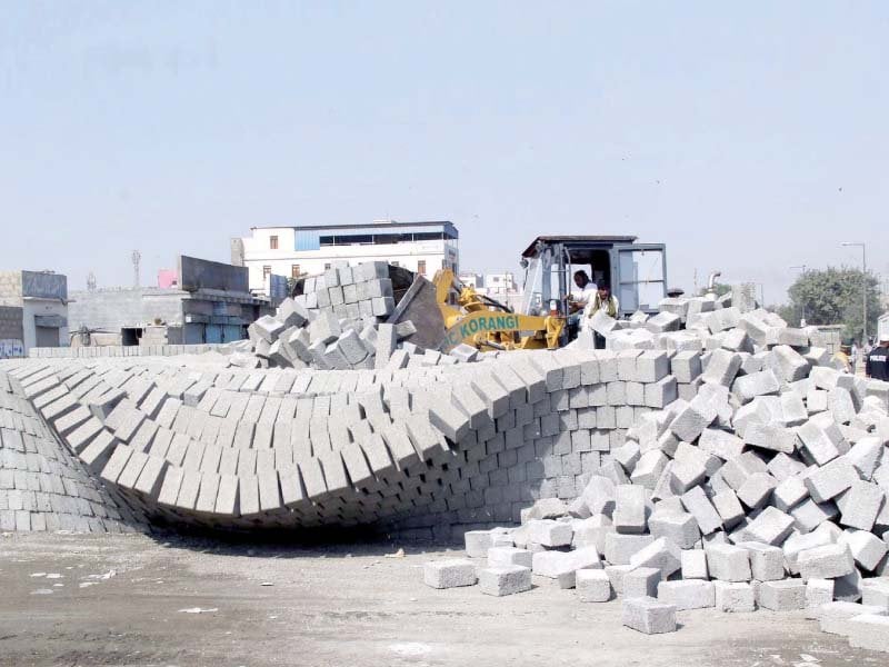 extractors remove blocks of cement as part of the anti encroachment drive in korangi under the supervision of kda on wednesday photo ppi