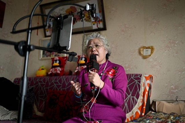 retiree wang jinxiang performing live over the internet from her home in beijing photo afp