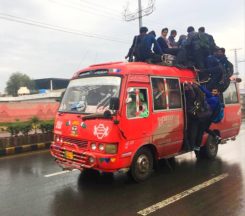 school children travel in a van during rain in lahore photo express