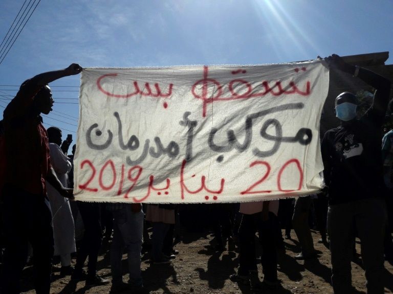 sudanese demonstrators hold up a banner bearing a slogan calling for the overthrow of the regime during an anti government protest in khartoum 039 s twin city omdurman on january 2019 photo afp