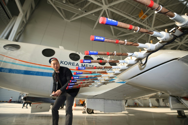 an aircraft from the korea meterological administration is fitted to disperse silver iodide a compound believed to cause rain to fall in a hanger at gimpo airport in seoul photo afp