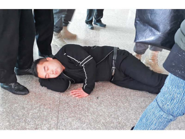 a chinese national lies on the floor of iia to protest against duty on cell phones photo express a chinese national lies on the floor of iia to protest against duty on cell phones photo express