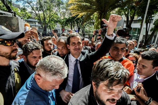 venezuela 039 s national assembly head and the country 039 s self proclaimed 039 acting president 039 juan guaido c waves at opposition supporters as he leaves a gathering in eastern caracas photo afp