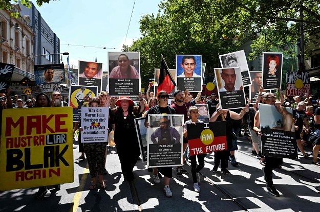 people hold up placards of aboriginal people who have allegedly died in police custody as they take part in an quot invasion day quot rally on australia day in melbourne on january 26 2019 photo afp