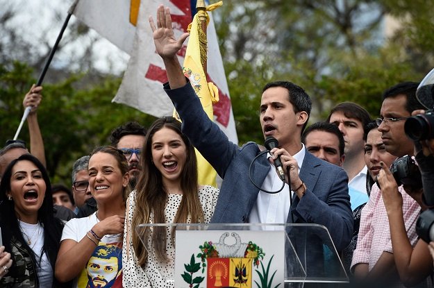 the head of venezuela 039 s national assembly and the country 039 s self proclaimed quot acting president quot juan guaido r speaks next to his wife fabiana rosales c and activist lilian tintori l wife of venezuelan opposition leader leopoldo lopez to a crowd of opposition supporters in caracas on january 26 2019 photo afp