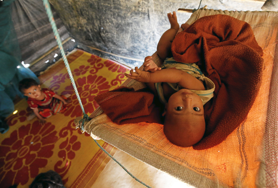 A Rohingya refugee child reacts to the camera as lies on a cradle at Kutupalang Unregistered Refugee Camp, in Cox's Bazar, Bangladesh. PHOTO: REUTERS