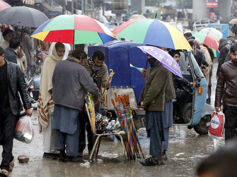a man sells umbrellas during rain in peshawar photo ppi