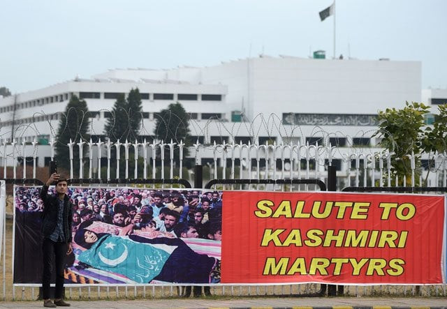 a cpoliceman talks on his phone near a banner hanged on the premises of the parliament building during a protest to mark the kashmir solidarity day in islamabad on february 5 2019 photo afp a cpoliceman talks on his phone near a banner hanged on the premises of the parliament building during a protest to mark the kashmir solidarity day in islamabad on february 5 2019 photo afp