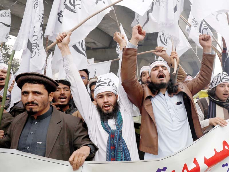 supporters of jamaat ud dawa jud hold flags as they chant slogans during a rally to mark kashmir day in peshawar photo reuters