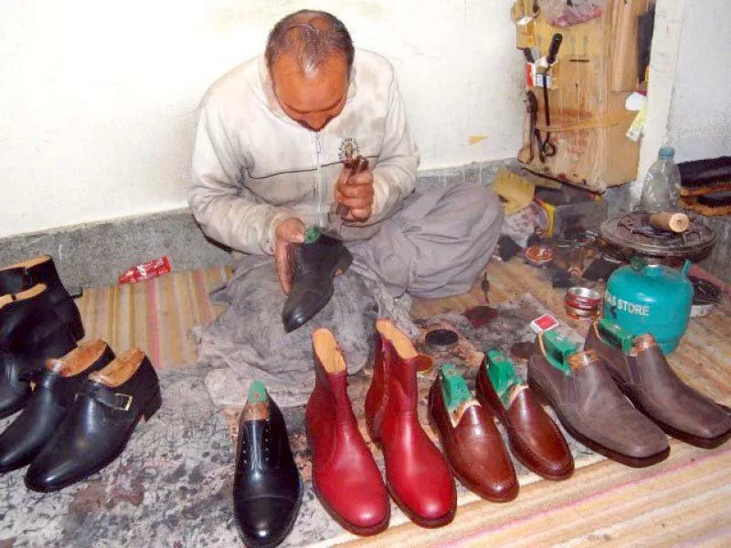 a shoemaker gives final touches to shoes at his workplace photo express a shoemaker gives final touches to shoes at his workplace photo express