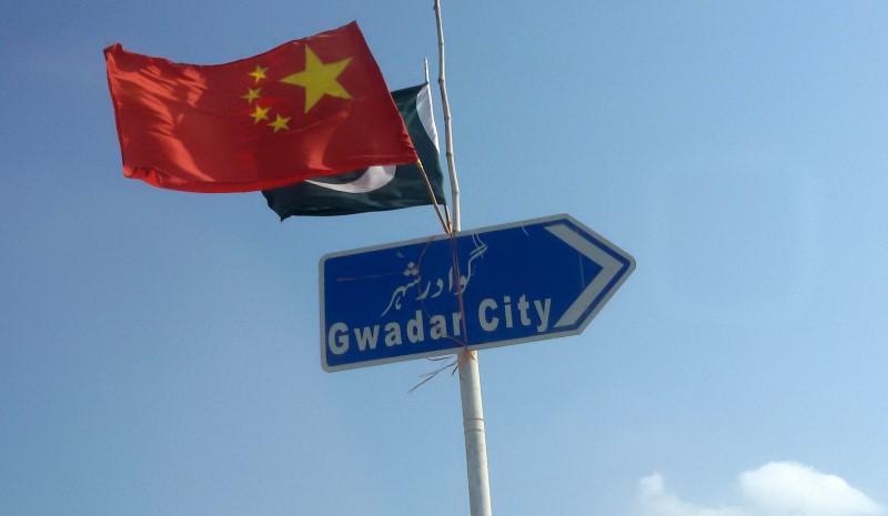 chinese and pakistani flags fly on a sign board along a road towards gwadar photo file