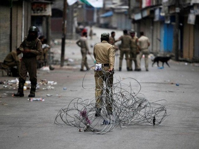 an indian policeman pulls concertina wire to lay a barricade on a road during a curfew in srinagar july 12 2016 photo reuters file