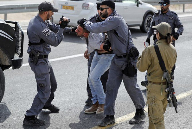 a file photo of an israeli policeman filming a palestinian as others hold him as he is being detained on october 19 2018 photo afp a file photo of an israeli policeman filming a palestinian as others hold him as he is being detained on october 19 2018 photo afp